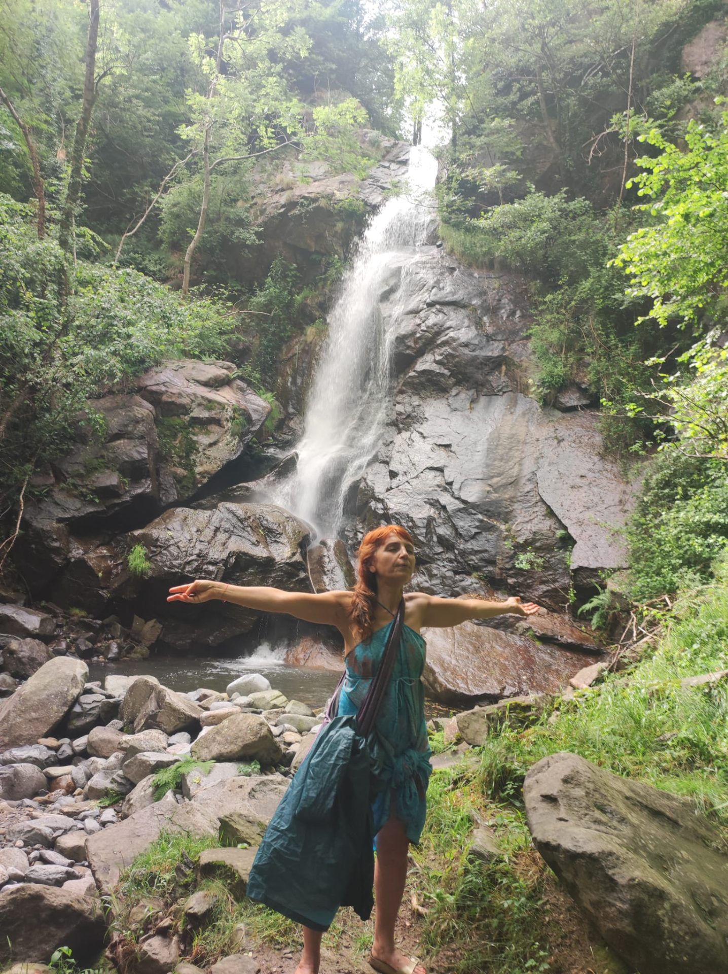 Cinzia Nardelli con le braccia aperte davanti a una cascata